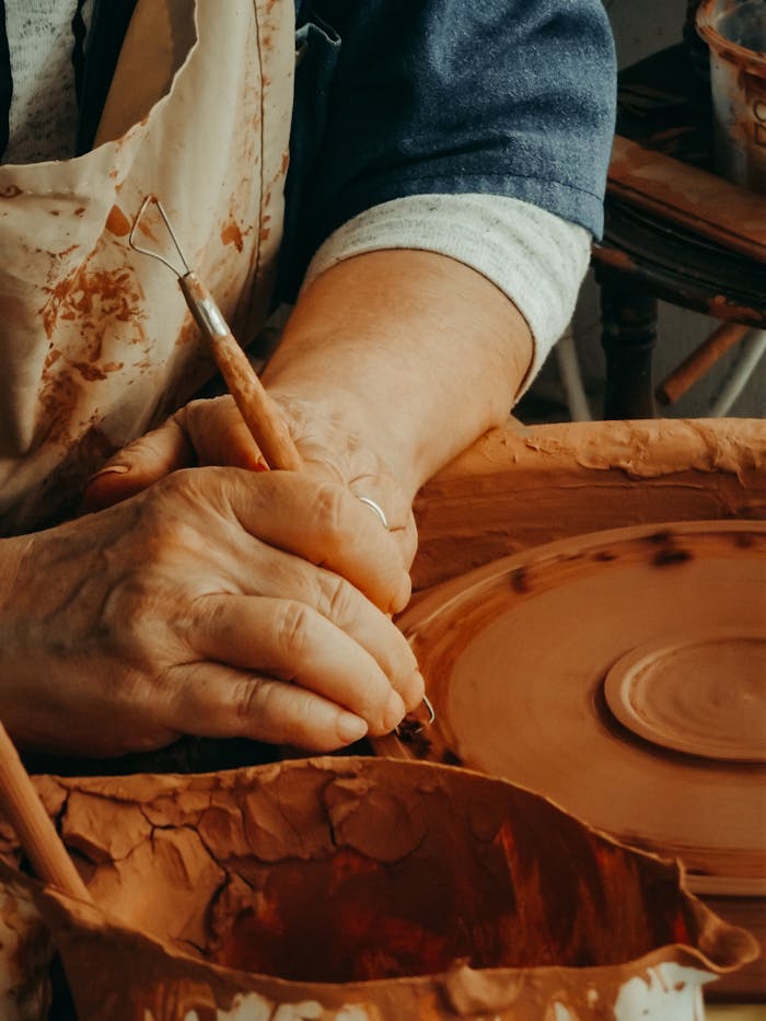 why-choose-us Close-up of hands crafting pottery on a spinning wheel, showcasing the art of ceramics.